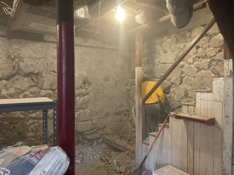 Mason repairing stone foundation interior walls